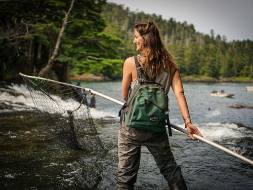 Woman fishes wearing Sagebrush Dry Gear Green Hip & Deck Pack